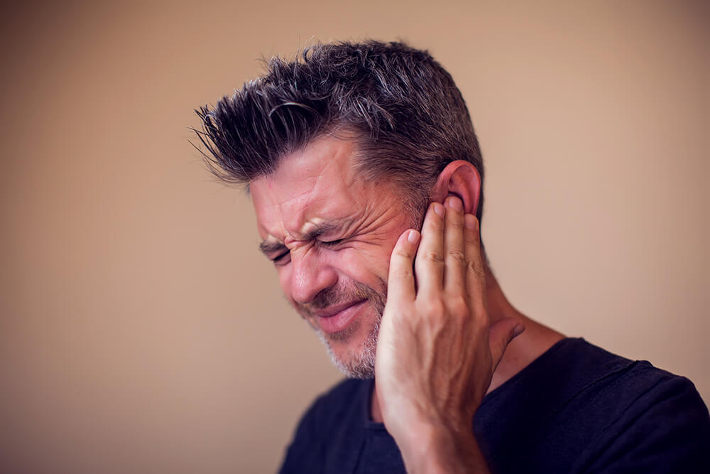 Mann mit Ohrenschmerzen - Tinnitus